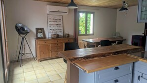 Una cocina con armarios de madera, una mesa de comedor y un ventanal grande.