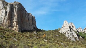 Un paisaje montañoso agreste con riscos escarpados y vegetación escasa.