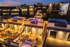 Un edificio residencial moderno con varios niveles, zonas de estar al aire libre y una terraza con jacuzzi.