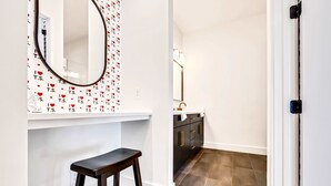 A modern bathroom with a vanity, mirror, and a stool. - Fall in Nashville: 2 homes, rooftop hot tubs, sleeps 24 near downtown (Nashville)