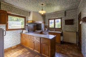A kitchen with wooden cabinets, a tiled backsplash, and a built-in stove. - Villa Le refuge du Pecheur (VEYRIER DU LAC)