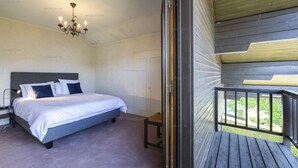 Een slaapkamer met een bed, nachtkastje en een kroonluchter.