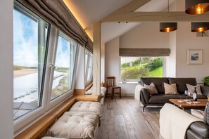 Una habitación con una cama, un sofá, una mesita de café y vistas al exterior.