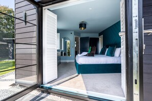 A bedroom with a large bed, a dresser, and a mirror.