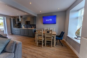 Dining table and kitchen with stunning views of the coast and Snowdonia mountain range, holiday cottage in Beaumaris, Anglesey - No. 66: Stylish Pet-Friendly Cottage in Beaumaris (Beaumaris)
