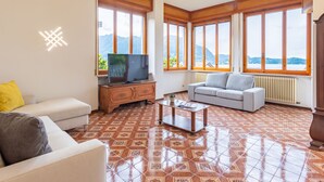 A living room with a TV, sofa, and a coffee table.