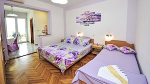 A bedroom with two beds, a wooden floor, and a painting on the wall. - Apartment Dajak by Interhome (Omiš)
