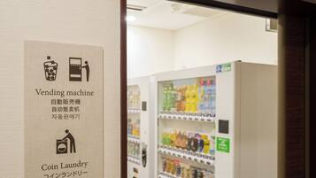 A vending machine with a coin laundry sign.