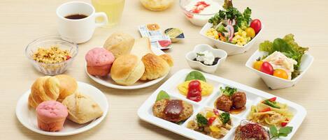 A variety of food items including pastries, salads, and a meat dish, arranged on a table.