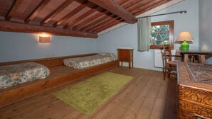 A room with a loft bed, a desk with a lamp, and a window with curtains. - POPULUS - Ground floor apartment of 115 m2 (Montaione)