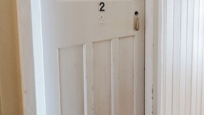 A white door with the number 2, a keyhole, and a door handle.