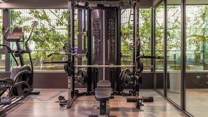 A gym with a weightlifting station, cardio machines, and large windows with a view of greenery. - Xi'an Zhonglou Fengdu Hotel (Yongxingfang Changlemen Subway Station Branch) (Xi'an)