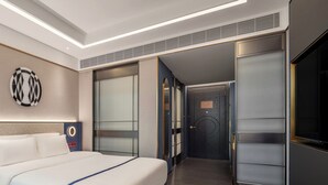 A modern hotel room with a large bed, a desk, and a walk-in closet. - Xi'an Zhonglou Fengdu Hotel (Yongxingfang Changlemen Subway Station Branch) (Xi'an)