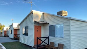 A single-story mobile home with a small porch, two windows, and a door marked with the number 2. - Longreach Apartments (Longreach)