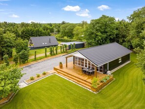Relax in a serene outdoor space with a large patio and comfortable seating area surrounded by lush greenery.