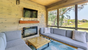 A wooden interior with a TV mounted on the wall, a sofa, and a coffee table. - Modern Hilton Head Island Villa w/ Pool Access! (Hilton Head Island)