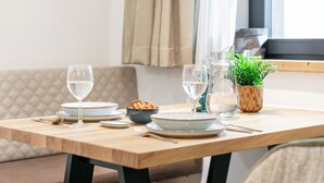 A dining table set with plates, bowls, glasses, and a pitcher.