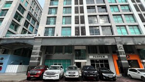 Un immeuble à plusieurs étages doté d’une architecture moderne, avec une enseigne « FUJIFILM » bien visible au rez-de-chaussée.