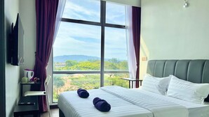 Une chambre d’hôtel avec un grand lit, un bureau, une chaise et un téléviseur fixé au mur.