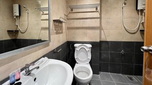 Une salle de bain moderne équipée d’un lavabo, de toilettes et d’une douche.