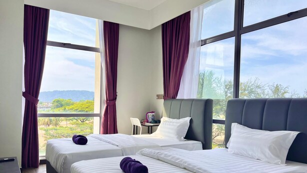 Une chambre d’hôtel avec deux lits, de grandes fenêtres et une vue sur l’extérieur.