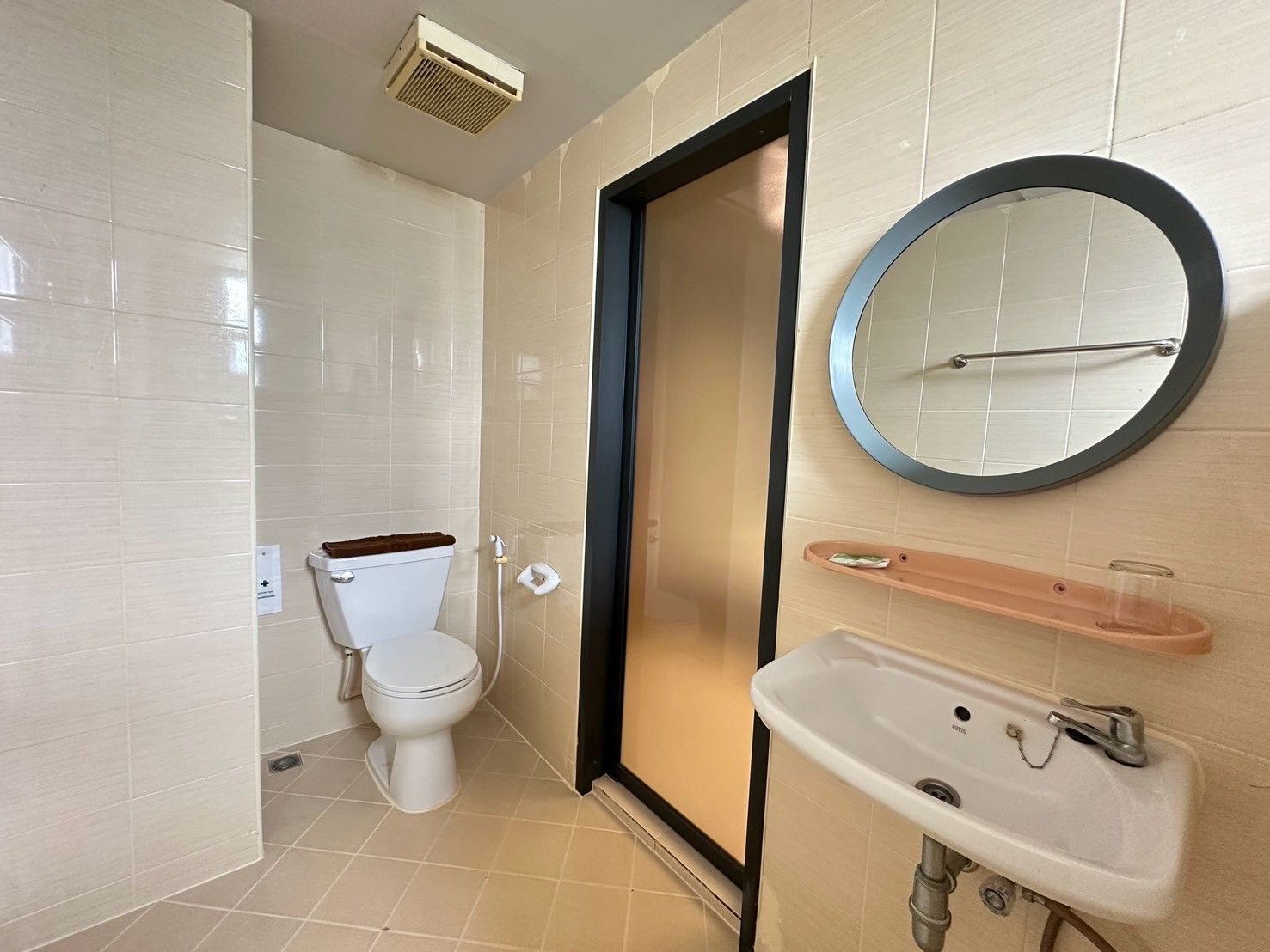A bathroom with a toilet, a sink, a mirror, and a towel rack.
