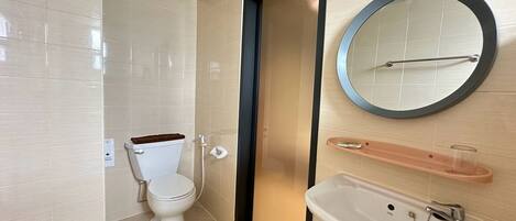 A bathroom with a toilet, a sink, a mirror, and a towel rack.