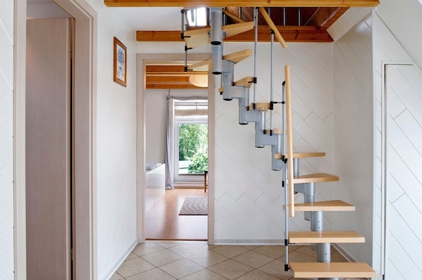 Un escalier moderne avec une finition en bois et des rampes en métal.