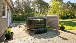 A hot tub on a wooden deck with a wooden fence and greenery in the background. - "Rohan" - 700m from the sea by Interhome (Rødby)
