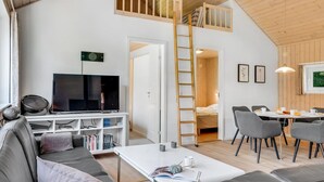 A modern loft-style living space with a loft bed, a television, a dining area, and a cozy seating area. - "Rohan" - 700m from the sea by Interhome (Rødby)