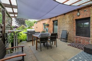 Un'area patio con barbecue, sedie e tavolo.