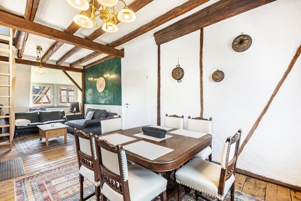A dining area with a wooden table, chairs, and a chandelier. - Spacious Holiday Apartment with Fireplace in Winzerhaus Schenk, with Mountain View and Wi-Fi (Neef)