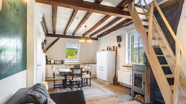 A cozy interior with a wooden ceiling, a dining area, a kitchen, and a fireplace. - Spacious Holiday Apartment with Fireplace in Winzerhaus Schenk, with Mountain View and Wi-Fi (Neef)
