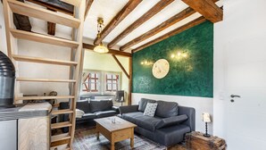 A cozy living room with a sofa, coffee table, and a wooden ladder. - Spacious Holiday Apartment with Fireplace in Winzerhaus Schenk, with Mountain View and Wi-Fi (Neef)