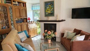 Un salon avec une cheminée, des canapés, une table basse et une bibliothèque.