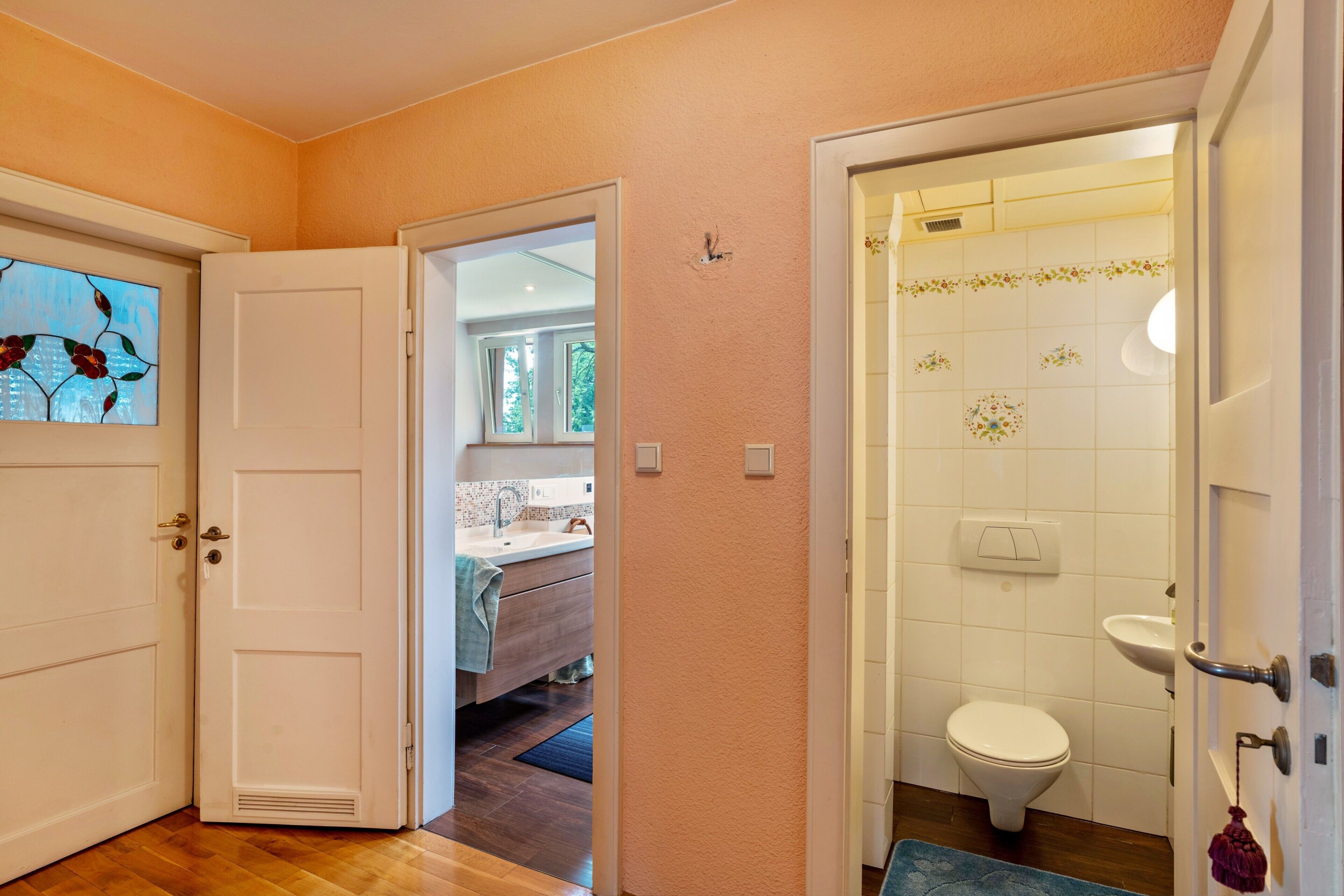 A bathroom with a toilet, sink, and a shower area.
