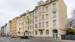 A row of multi-story buildings with a consistent architectural style, featuring large windows and balconies. - Apartment 'Ferienwohnung Am Theaterplatz' with Wi-Fi (Gera)