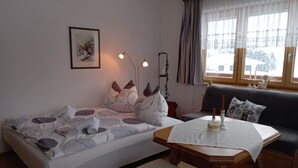 Une pièce confortable avec un lit, une table et un canapé.