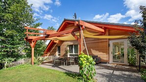 A wooden house with a patio, outdoor seating, and a garden. - Holiday Apartment "Leben Am Weinberg" with Shared Terrace, Shared Garden & Wi-Fi (Herbstein)