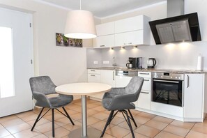 Enjoy meals in this kitchen with oven, round table, and pendant light.