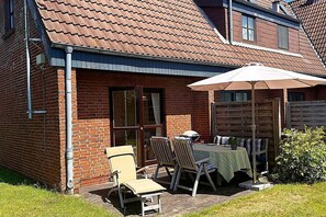 Enjoy a patio with a table for two, umbrella, and comfortable seating.