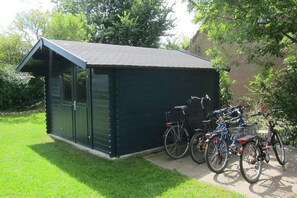 Guests can store bicycles in this shed, nestled in a well-manicured garden.