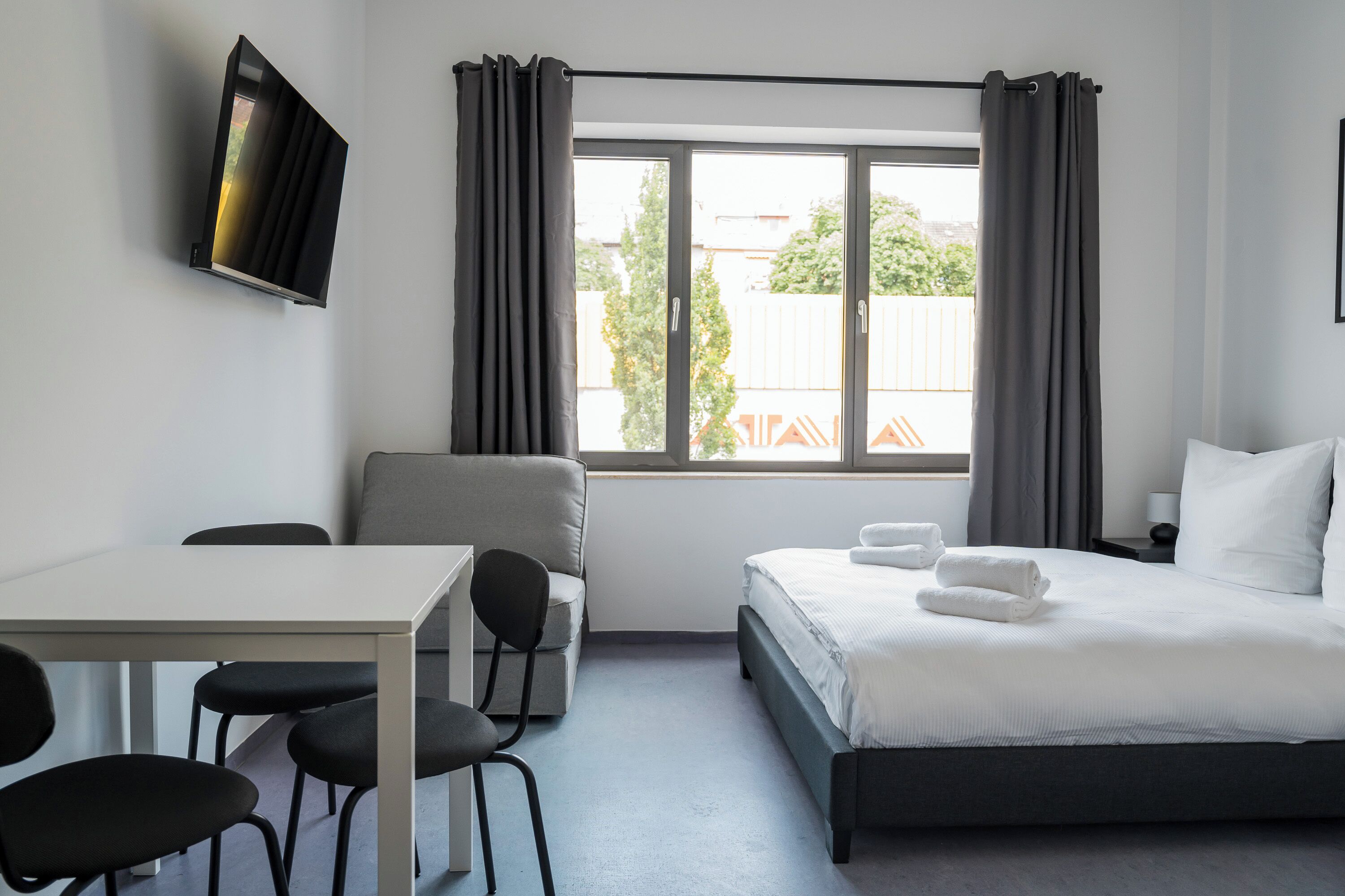 Una habitación de hotel moderna con una cama, un escritorio y una silla.