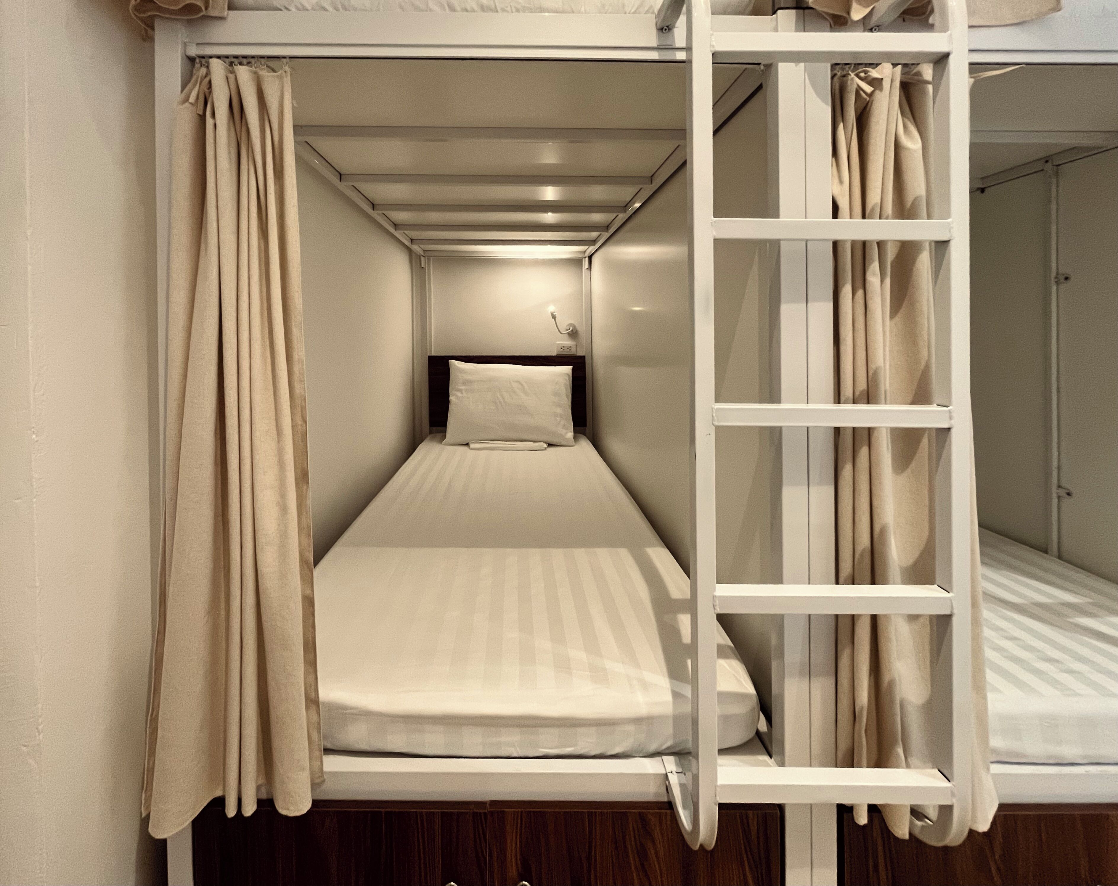 Una cama litera con escalera, una cama individual y un cabecero.