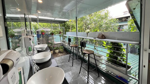 Un baño moderno con un lavamanos grande, un espejo y una ventana con vistas a zonas verdes.