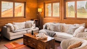 Interior acogedor de una cabaña de madera con un sofá, una mesa de centro y una lámpara.