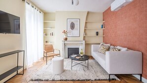 A modern living room with a fireplace, a sofa, a coffee table, and a TV.