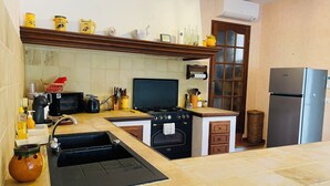 Eine Küche mit Herd, Mikrowelle, Spüle und Kühlschrank.