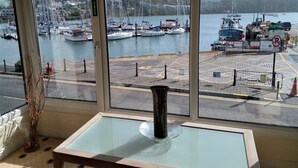 Vista da una stanza con ampie finestre su un porto turistico con barche e yacht.