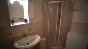 A bathroom with a sink, mirror, and shower. - The House of Flowers, in the heart of the Gulf of Macari 2.5 km from the sea. (Castelluzzo)